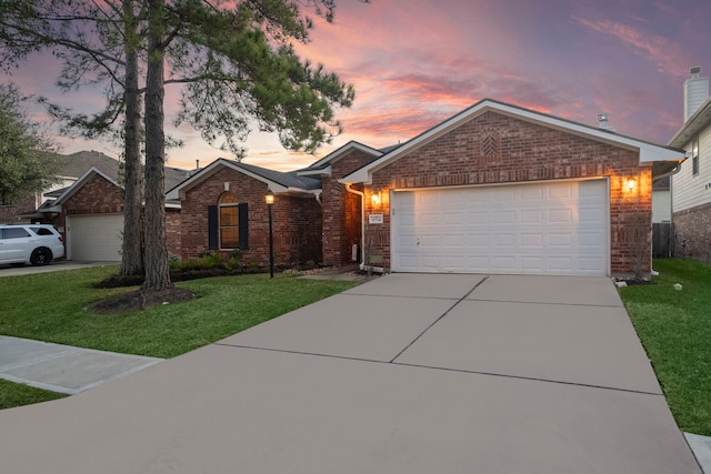 ranch-style house with a garage, driveway, a front yard, and brick siding