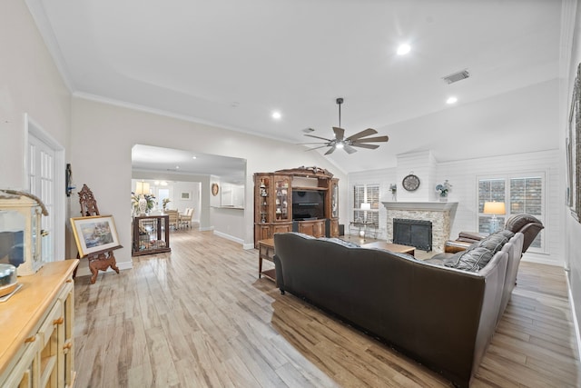 living room with a fireplace, visible vents, ornamental molding, light wood-type flooring, and baseboards