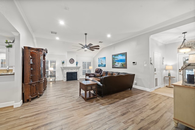 living room with ornamental molding, light wood-style flooring, a fireplace, and visible vents