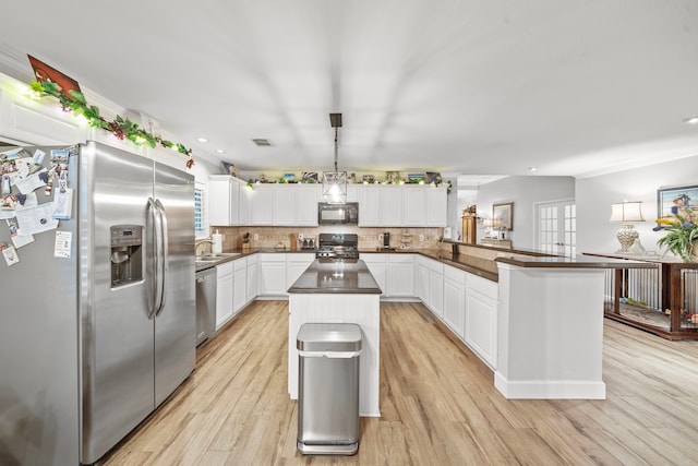 kitchen featuring a peninsula, white cabinetry, appliances with stainless steel finishes, decorative backsplash, and dark countertops