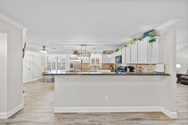 kitchen with a sink, dark countertops, backsplash, and stainless steel fridge with ice dispenser