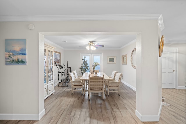 dining room with light wood-type flooring, ceiling fan, baseboards, and crown molding