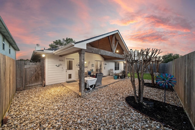 back of property featuring a fenced backyard and a patio