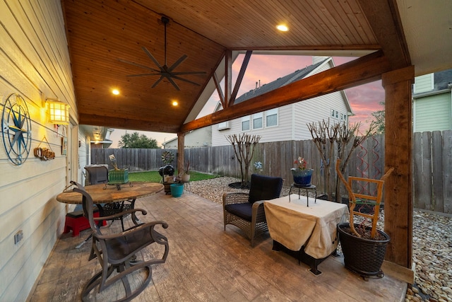 patio terrace at dusk with a fenced backyard and a ceiling fan