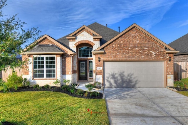 view of front facade with brick siding, a front yard, a garage, stone siding, and driveway