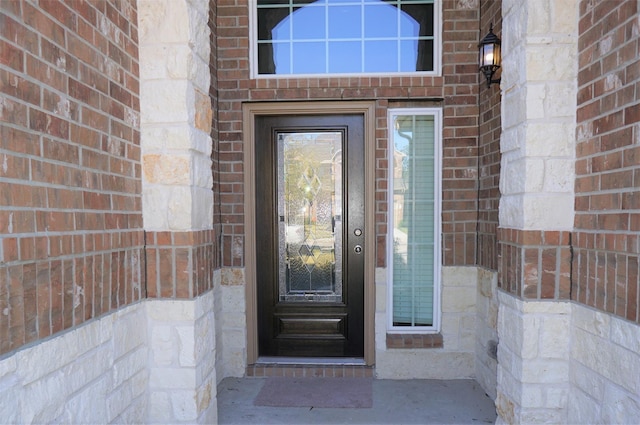 doorway to property featuring brick siding