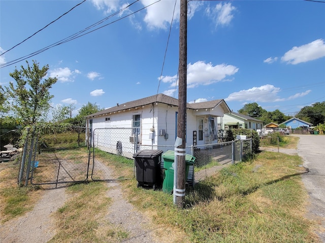 view of front of property featuring driveway, a fenced front yard, and a gate