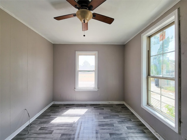 spare room featuring baseboards, wood finished floors, and crown molding