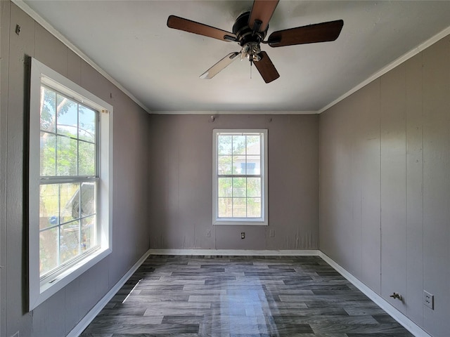 empty room featuring ornamental molding, dark wood-style flooring, baseboards, and a ceiling fan