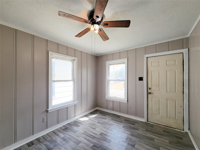 foyer featuring a decorative wall, a textured ceiling, and wood finished floors