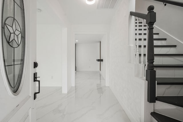 foyer featuring marble finish floor and visible vents