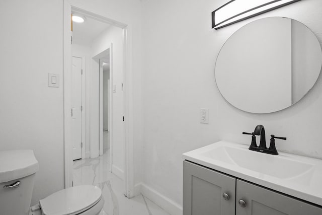 bathroom featuring marble finish floor, vanity, toilet, and baseboards