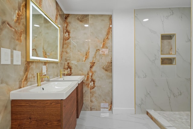 full bath with tile walls, marble finish floor, vanity, and a marble finish shower