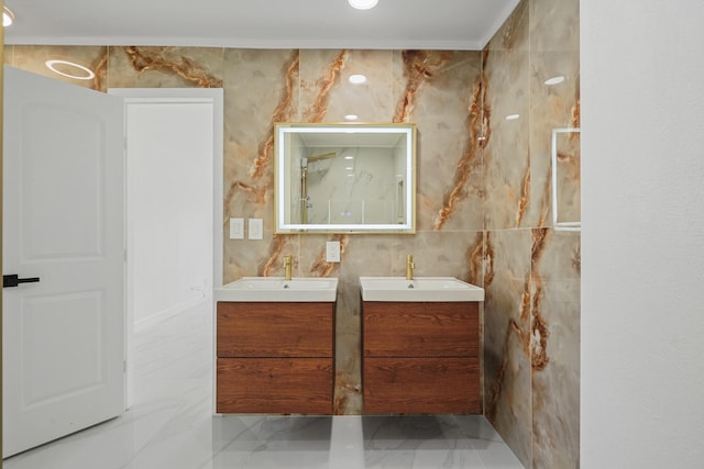 bathroom with marble finish floor, two vanities, a sink, and tile walls