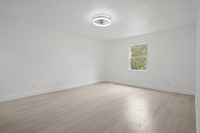 unfurnished room featuring light wood-type flooring and baseboards