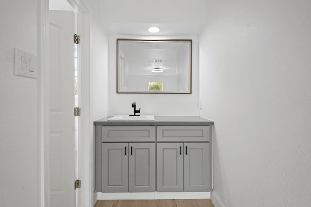 bathroom with baseboards, wood finished floors, and vanity