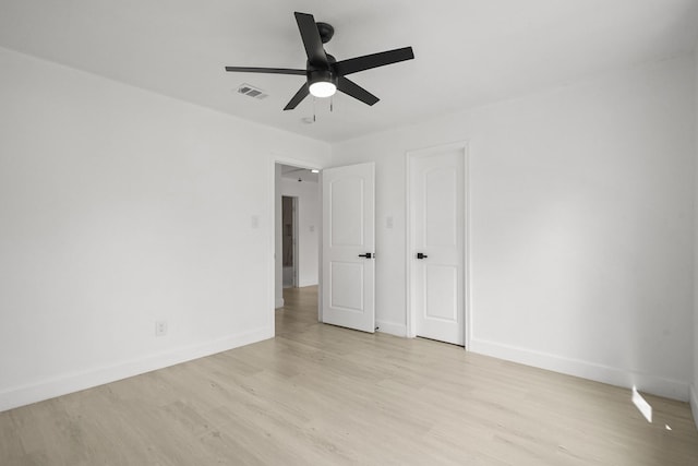 unfurnished bedroom with light wood-style flooring, a ceiling fan, visible vents, and baseboards