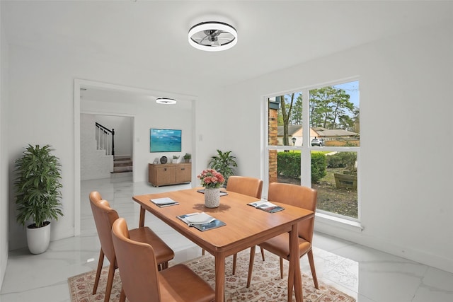 dining space with marble finish floor, stairway, and baseboards