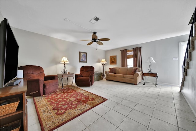 living area featuring light tile patterned floors, baseboards, visible vents, and a ceiling fan