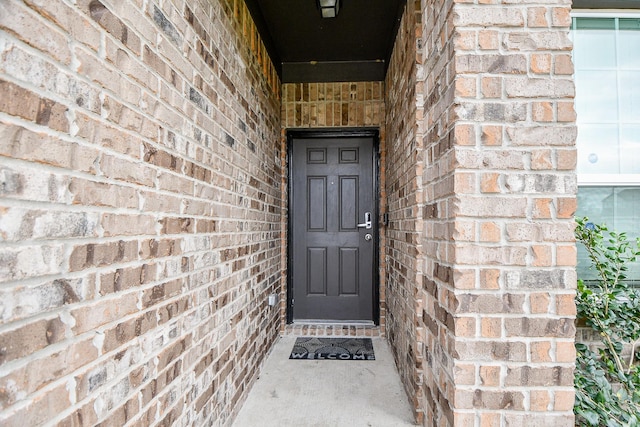 view of exterior entry with brick siding