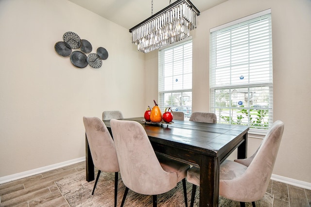 dining room with baseboards, a chandelier, and wood finished floors