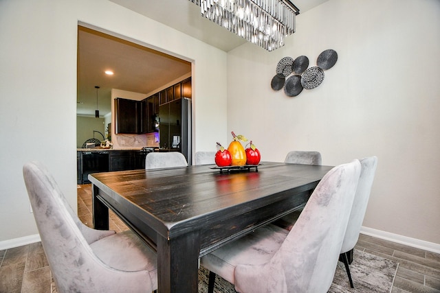 dining room with baseboards, an inviting chandelier, and recessed lighting