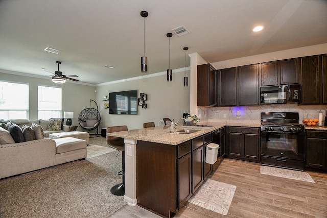 kitchen featuring tasteful backsplash, open floor plan, dark brown cabinetry, and black appliances