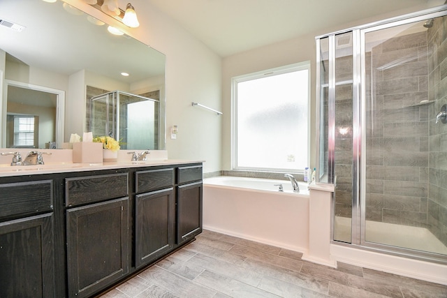 full bath featuring a stall shower, visible vents, a bath, a sink, and double vanity