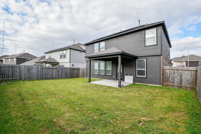 back of property with a yard, a patio area, and a fenced backyard
