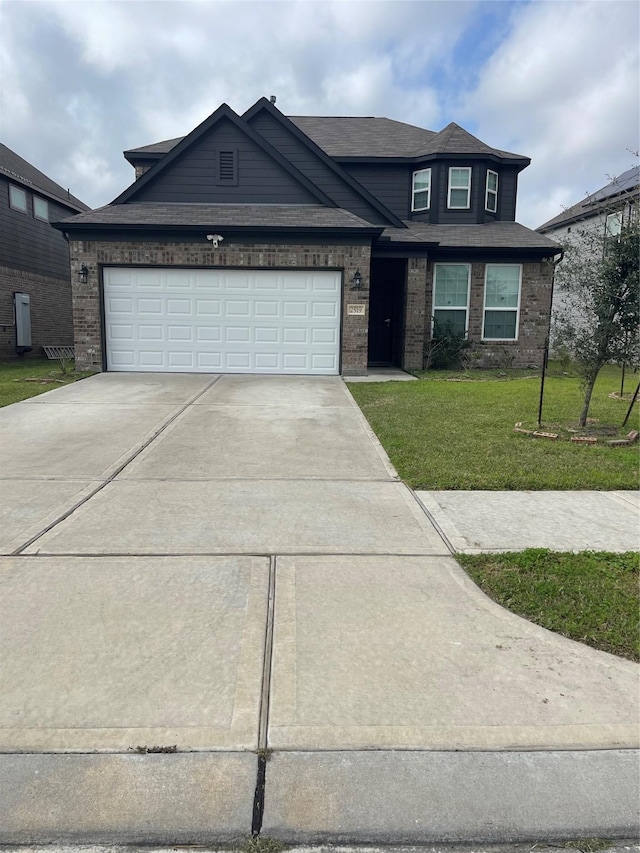 view of front of house featuring driveway, brick siding, a front yard, and an attached garage