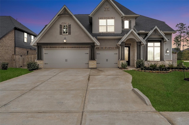 view of front of house with fence, a front lawn, concrete driveway, and stucco siding