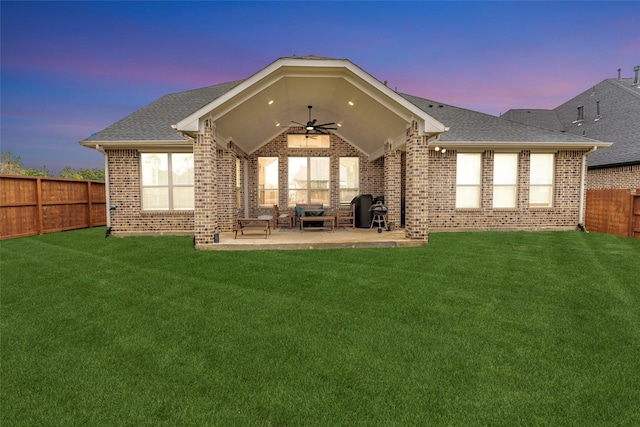 back of house featuring brick siding, a yard, a ceiling fan, a patio area, and a fenced backyard