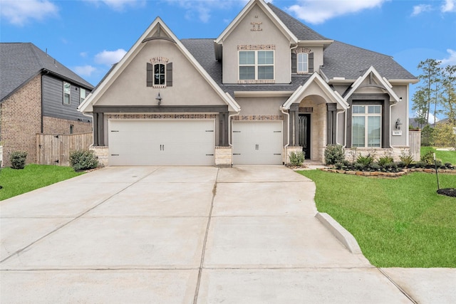 view of front facade featuring a shingled roof, an attached garage, fence, a front lawn, and stucco siding