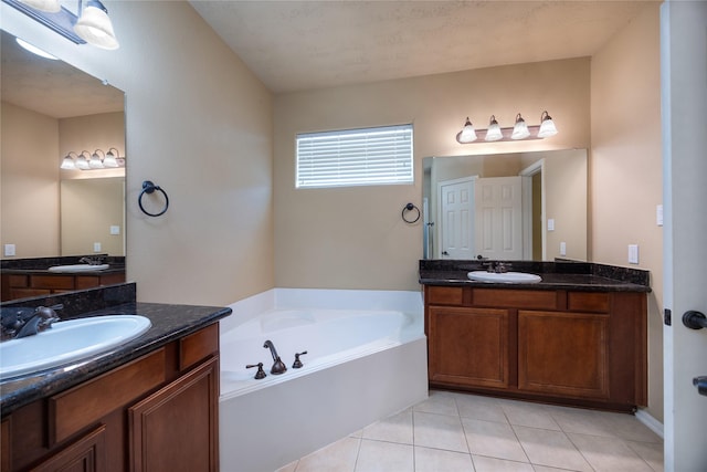 full bath featuring a garden tub, two vanities, tile patterned floors, and a sink