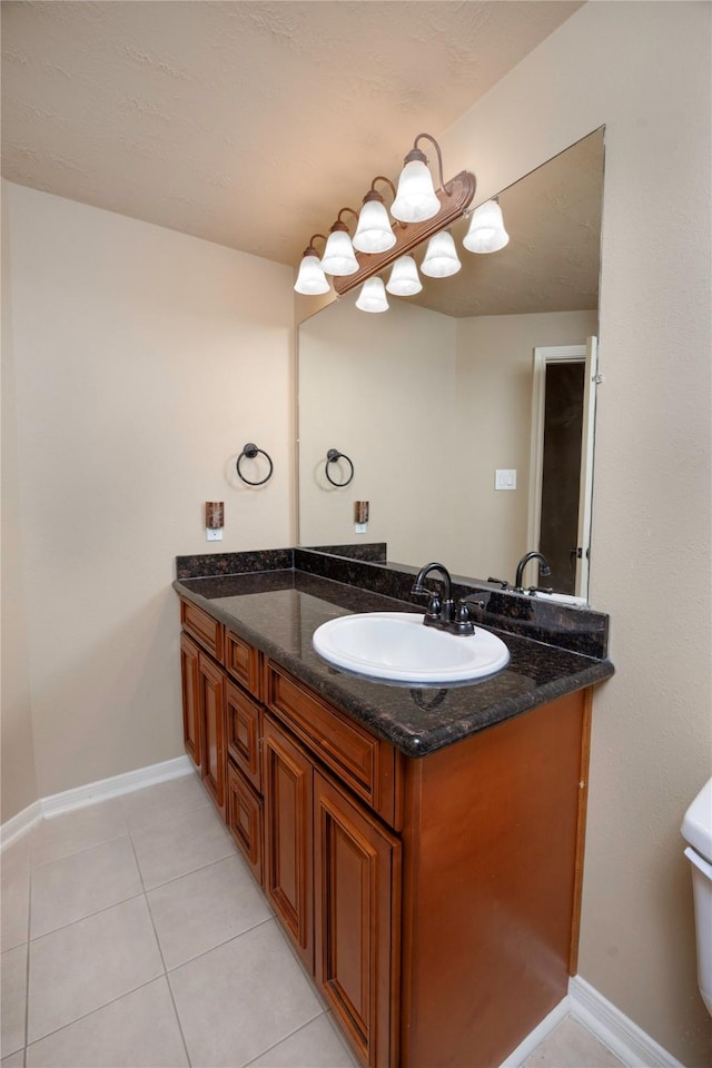 bathroom with tile patterned flooring, vanity, and baseboards