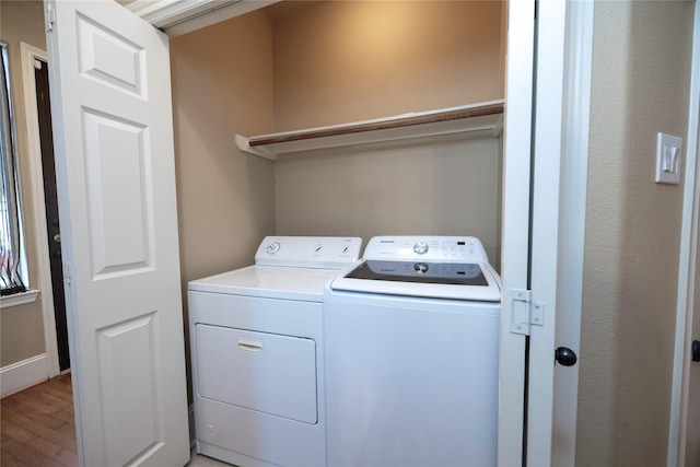 washroom with washer and dryer, laundry area, and light wood-style floors