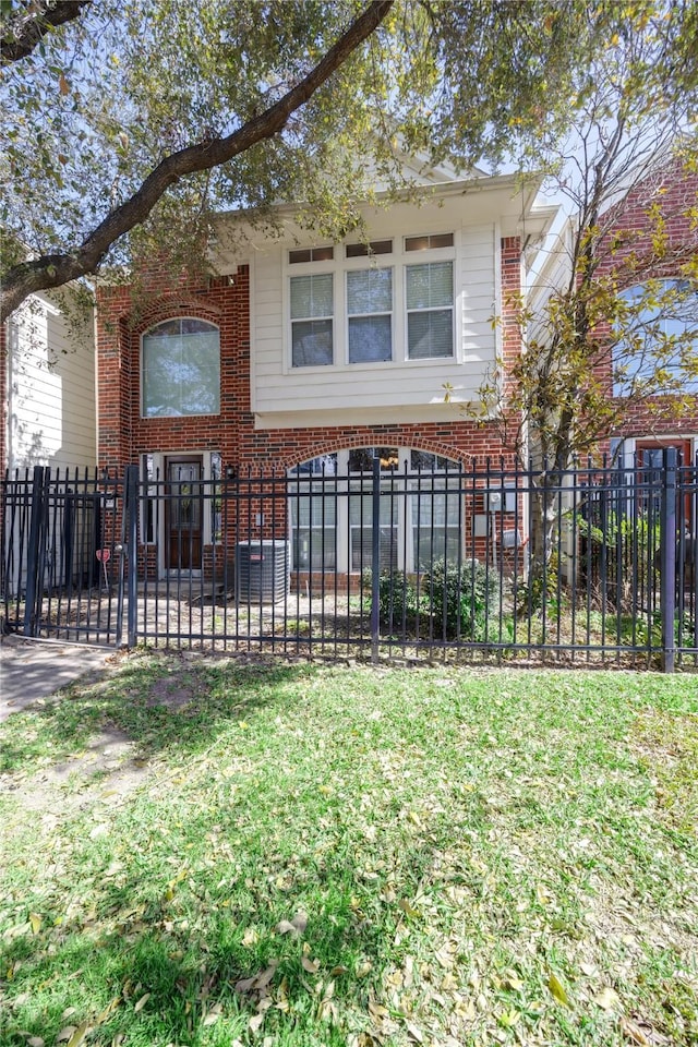 view of front of home featuring a fenced front yard, brick siding, and a front yard