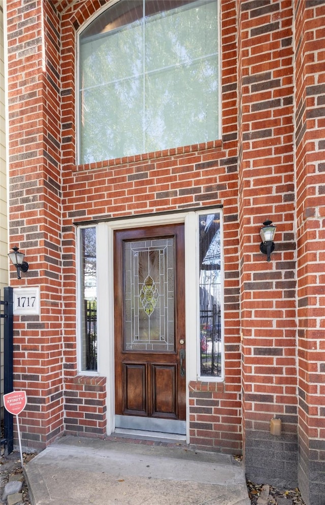 entrance to property featuring brick siding