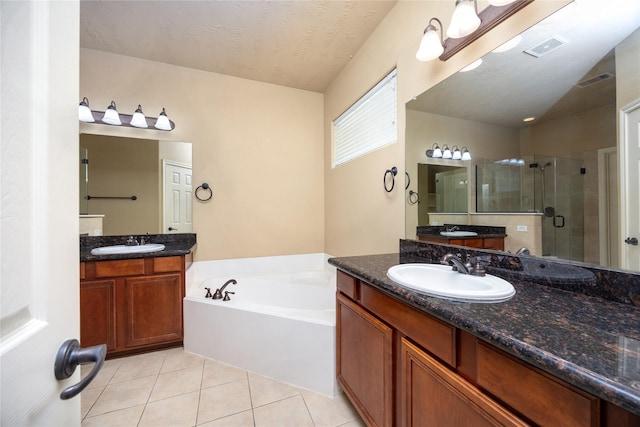 bathroom featuring tile patterned floors, visible vents, a shower stall, and a sink