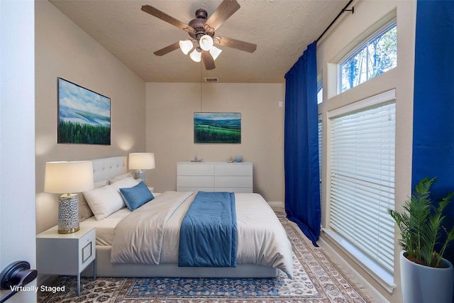 bedroom with ceiling fan, visible vents, and a textured ceiling