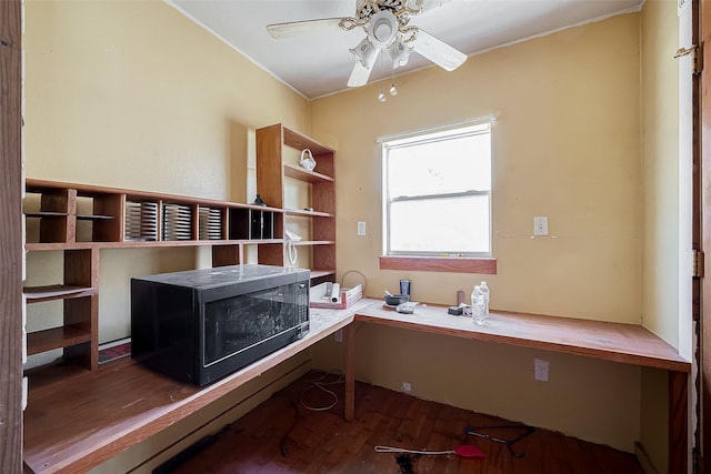 unfurnished office featuring ceiling fan, wood finished floors, and built in study area