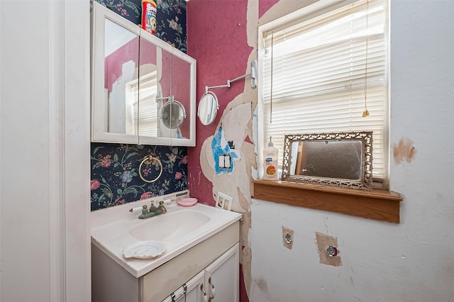 bathroom with vanity and wallpapered walls