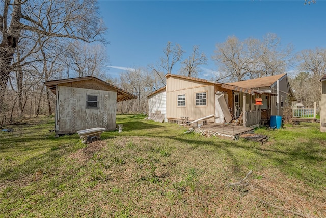 back of property featuring an outbuilding and a yard