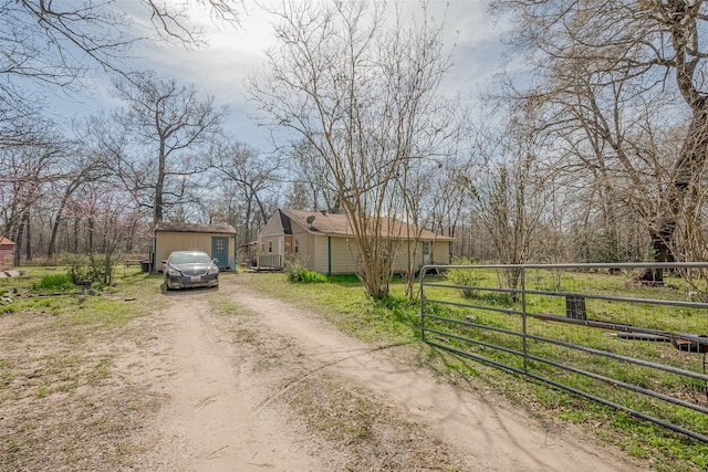 view of street featuring driveway, a gated entry, and a gate