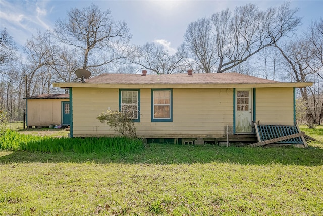 rear view of house featuring a yard