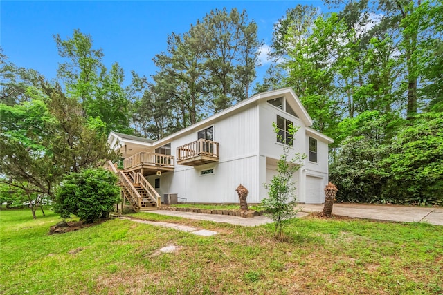 view of front of property featuring driveway, a garage, stairway, a wooden deck, and a front lawn