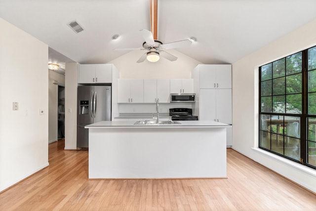 kitchen with visible vents, light wood-style flooring, appliances with stainless steel finishes, vaulted ceiling, and a sink