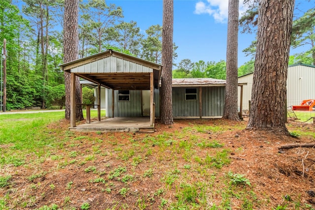 rear view of property with metal roof and an outdoor structure