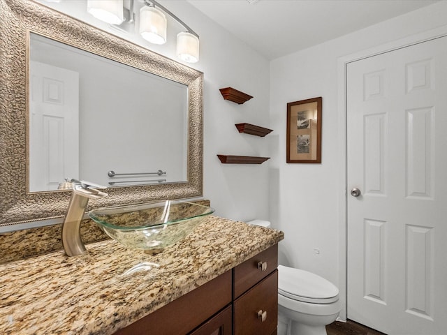 half bath featuring toilet and vanity