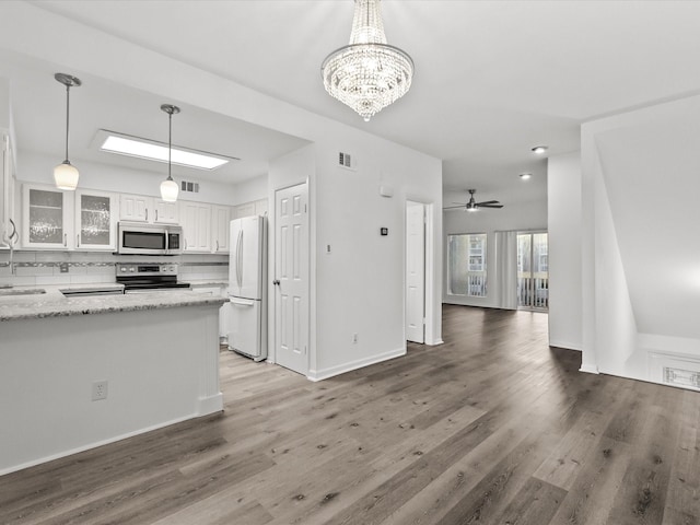 kitchen with white cabinets, tasteful backsplash, visible vents, and stainless steel appliances